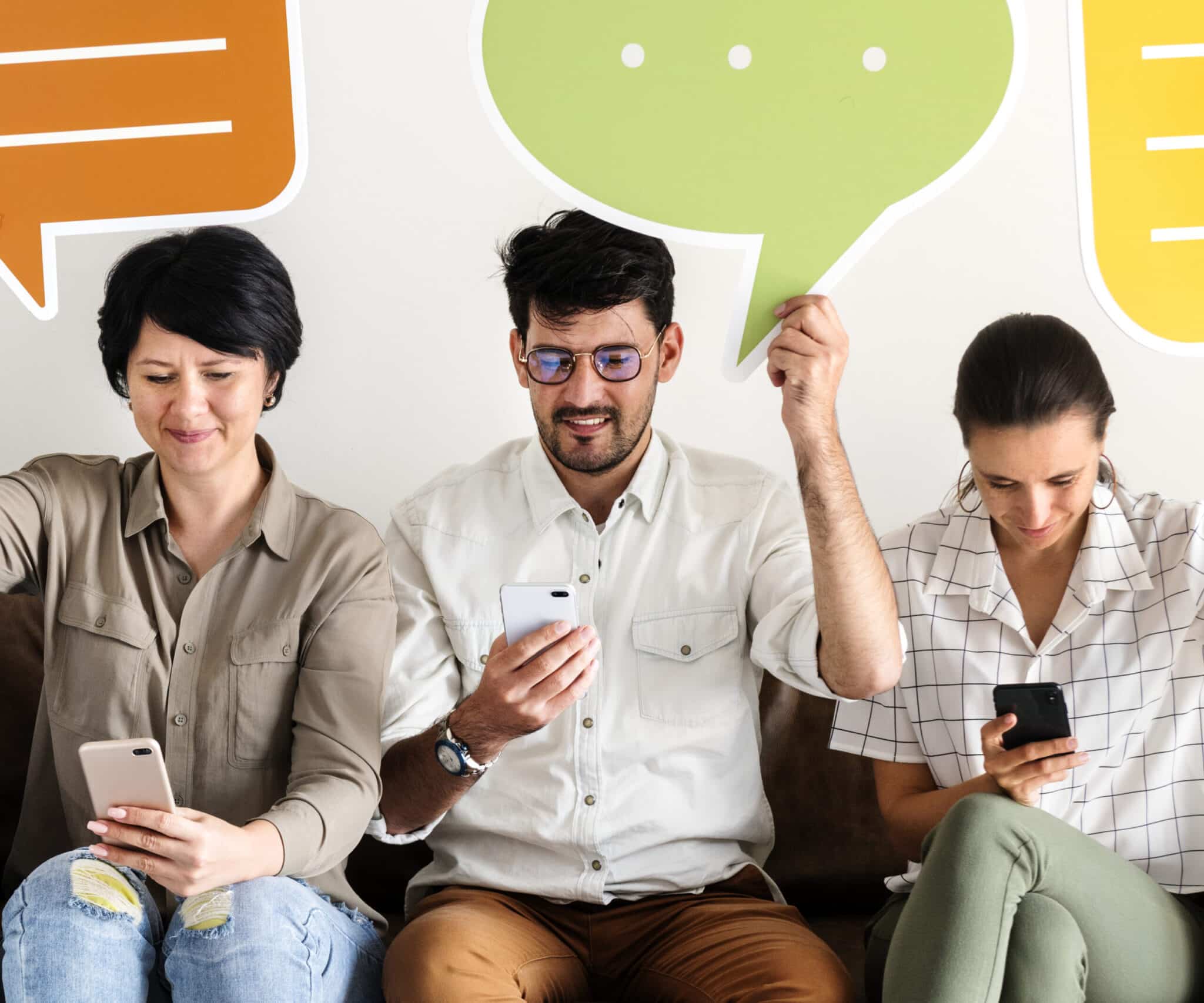 Co-workers sitting on couch and holding message icons