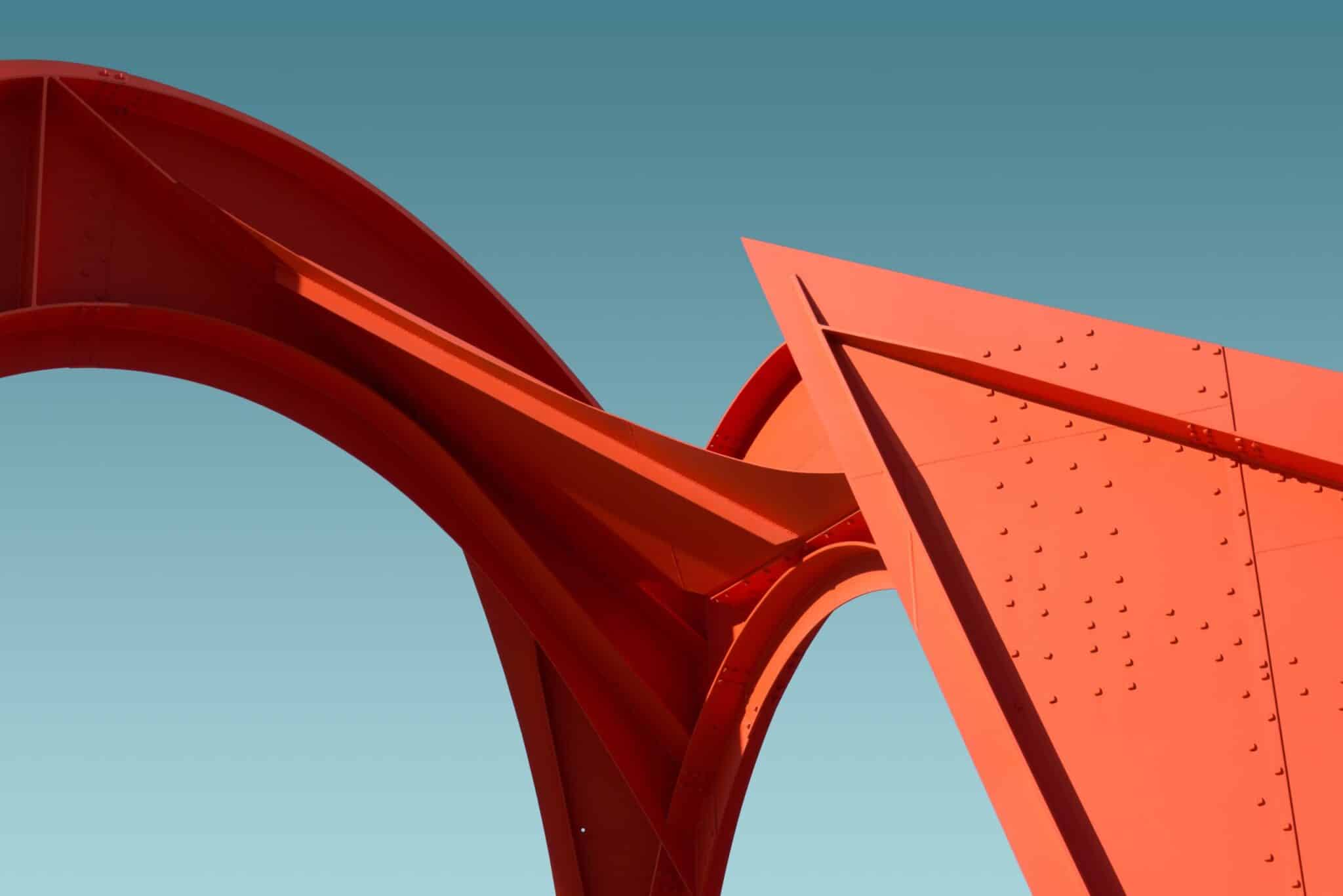 A low angle shot of a metal red structure under the clear blue sky